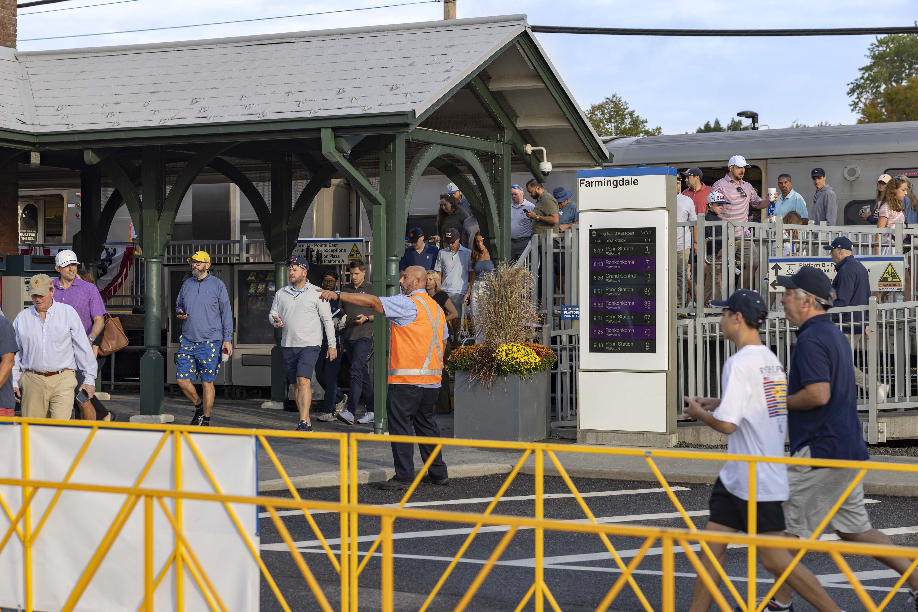 LIRR usher directing crowds getting off a train at LIRR Farmingdale Station for the 2025 Ryder Cup 