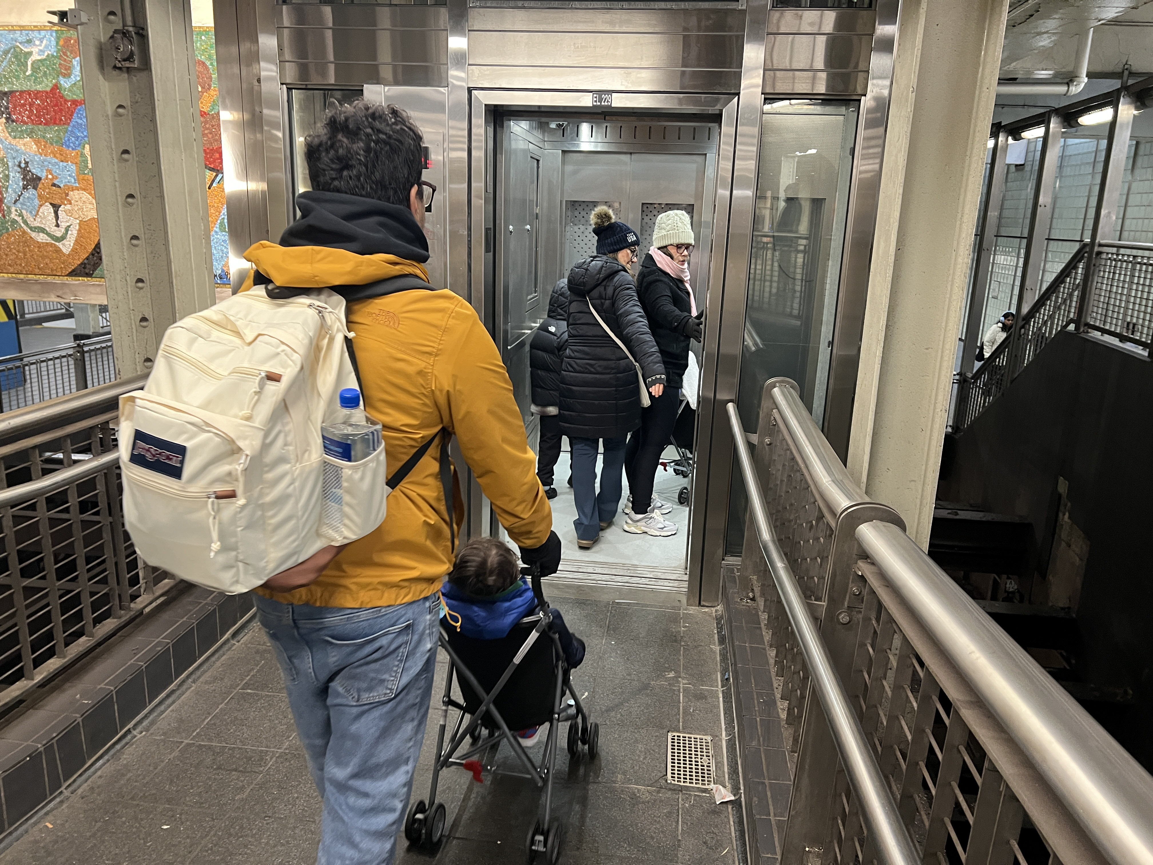 parent with stroller entering the newly replaced elevator at Times Sq-42 St 