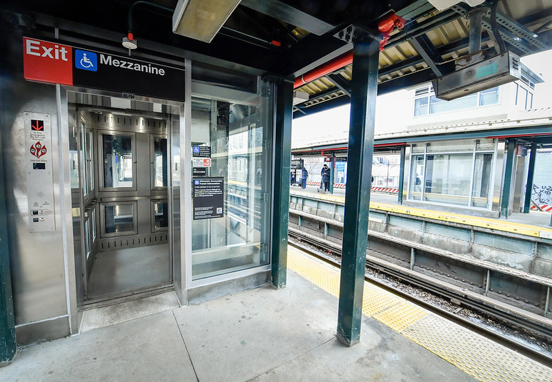 A view of an overground platform at Sheepshead Bay subway station, with a new elevator pictured on the left. Tracks and the other platform can be seen to the right. 