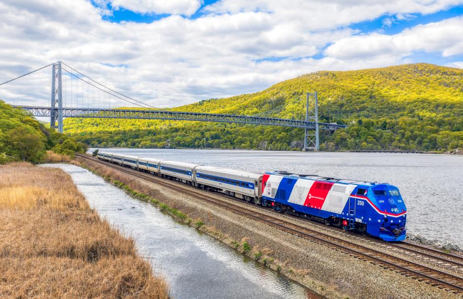 P32AC-DM locomotive No. 250, painted to celebrate America’s 250th anniversary, glides along the Hudson River near Manitou in Phillipstown, N.Y., just north of the Bear Mountain Bridge.