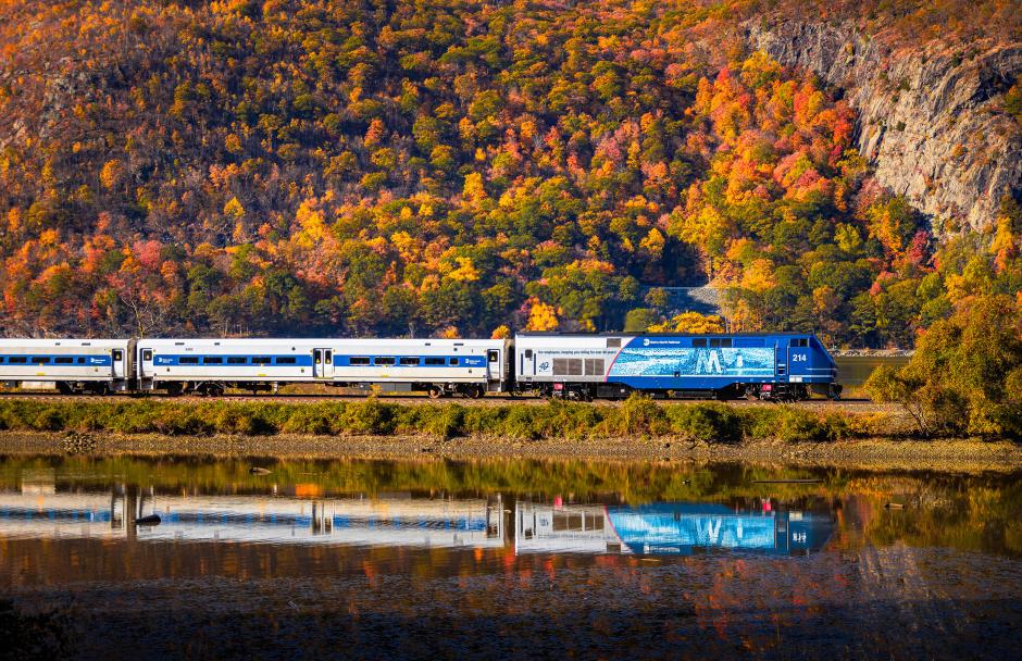 Employee Tribute locomotive P32AC-DM No. 214 leads Train 8807 north at Cold Spring, New York, on a crisp autumn morning, as the first colors of fall begin to brighten the Hudson Line.