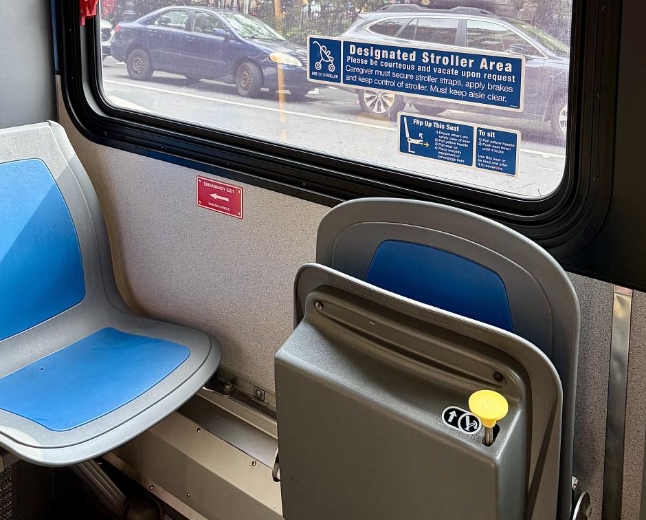 The open stroller area on an M11, where two seats near the rear door are flipped up so that a stroller can be parked in front of them.