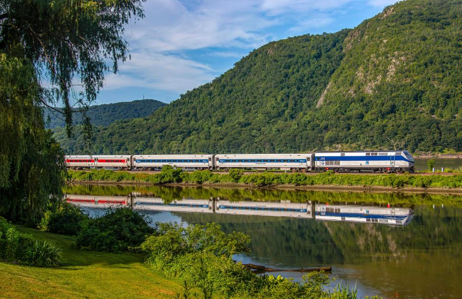 P32AC-DM No. 203, wearing the MTA Central heritage scheme, heads north along the Hudson Line near Cold Spring, New York, tracing the river’s edge through one of Metro-North’s most scenic corridors.