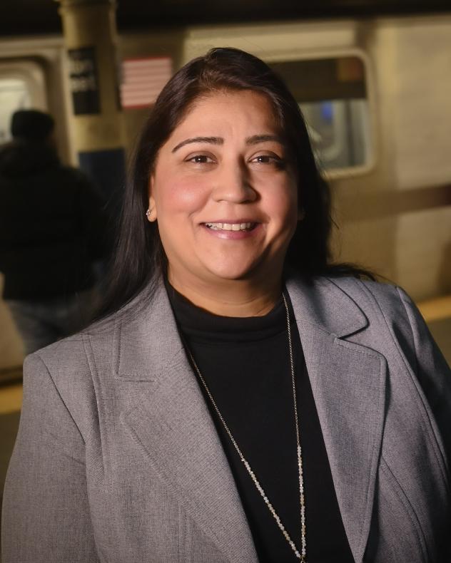 Headshot of Jai Patel, wearing a gray blazer jacket and a black turtleneck with a long necklace. 
