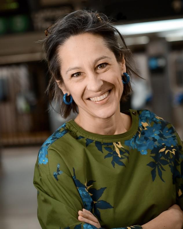 Juliette Michaelson wearing a green floral blouse in a subway station
