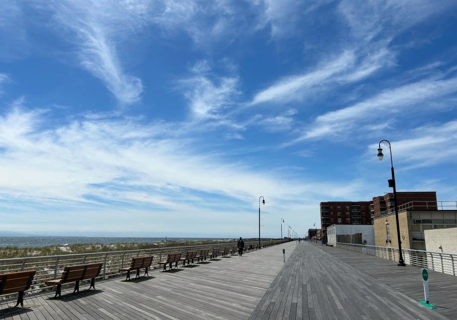 A boardwalk with ocean on the left side, and buildings on the right. 