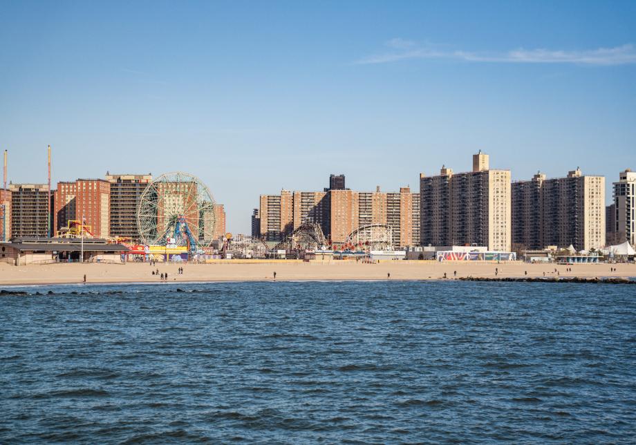 A view of the shoreline of Coney Island, New York. Landmarks like the Wonder Wheel and Coney Island Cyclone are visible. 