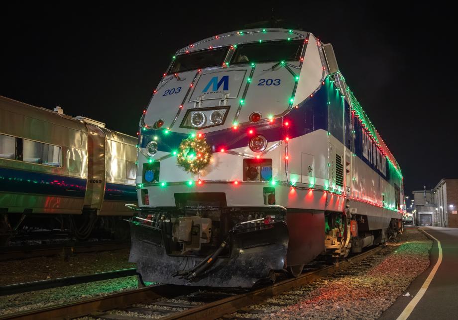 A Metro-North P32 diesel locomotive in "M Central" heritage livery with holiday lights
