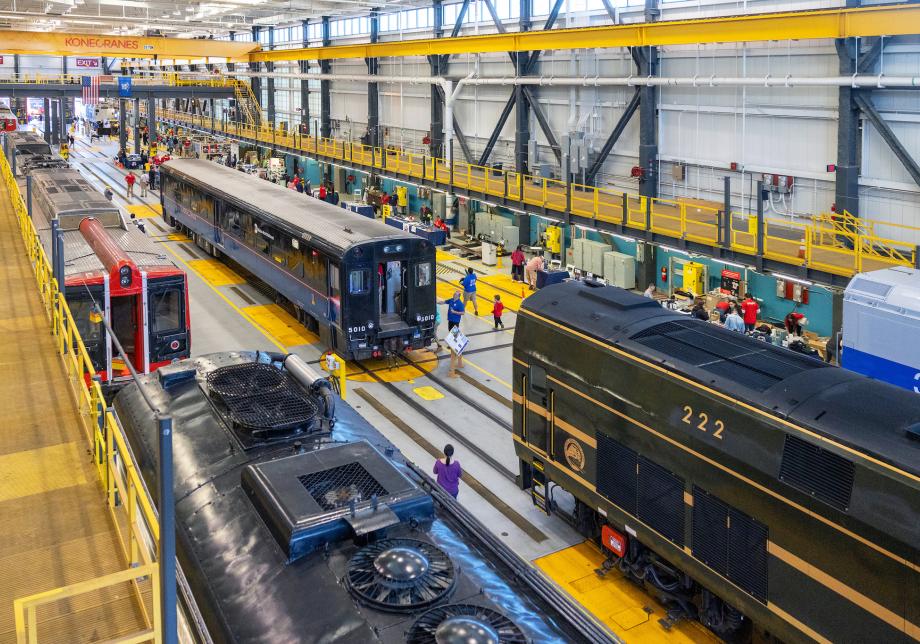 An aerial view of a train yard, with several locomotives parked along train tracks. 