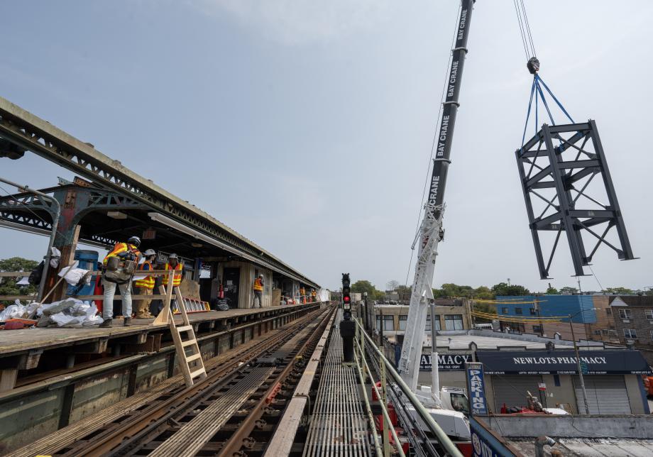 A photo showing a crane lifting elevator infrastructure into Mosholu Pkwy Station platform. 