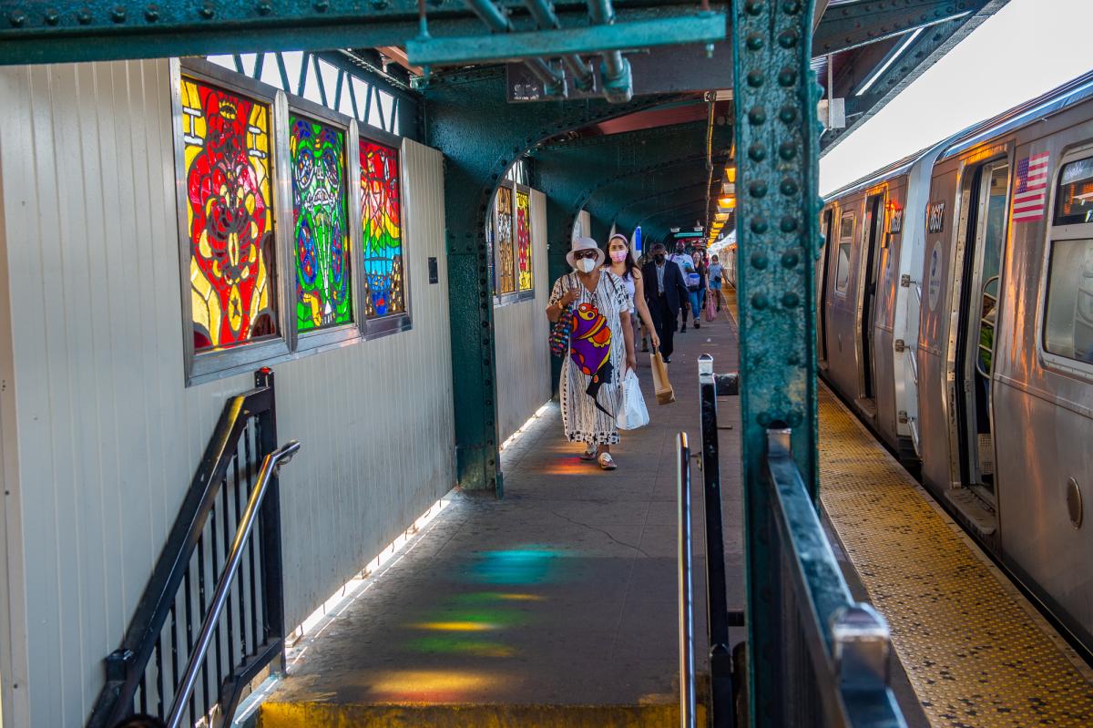 Artwork in faceted glass by Sol’Sax showing vibrant colors and intricate designs of city life and abstract symbols.