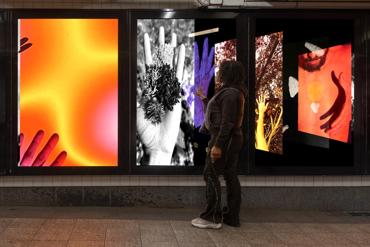 A person standing in front of photography lightboxes in a station.