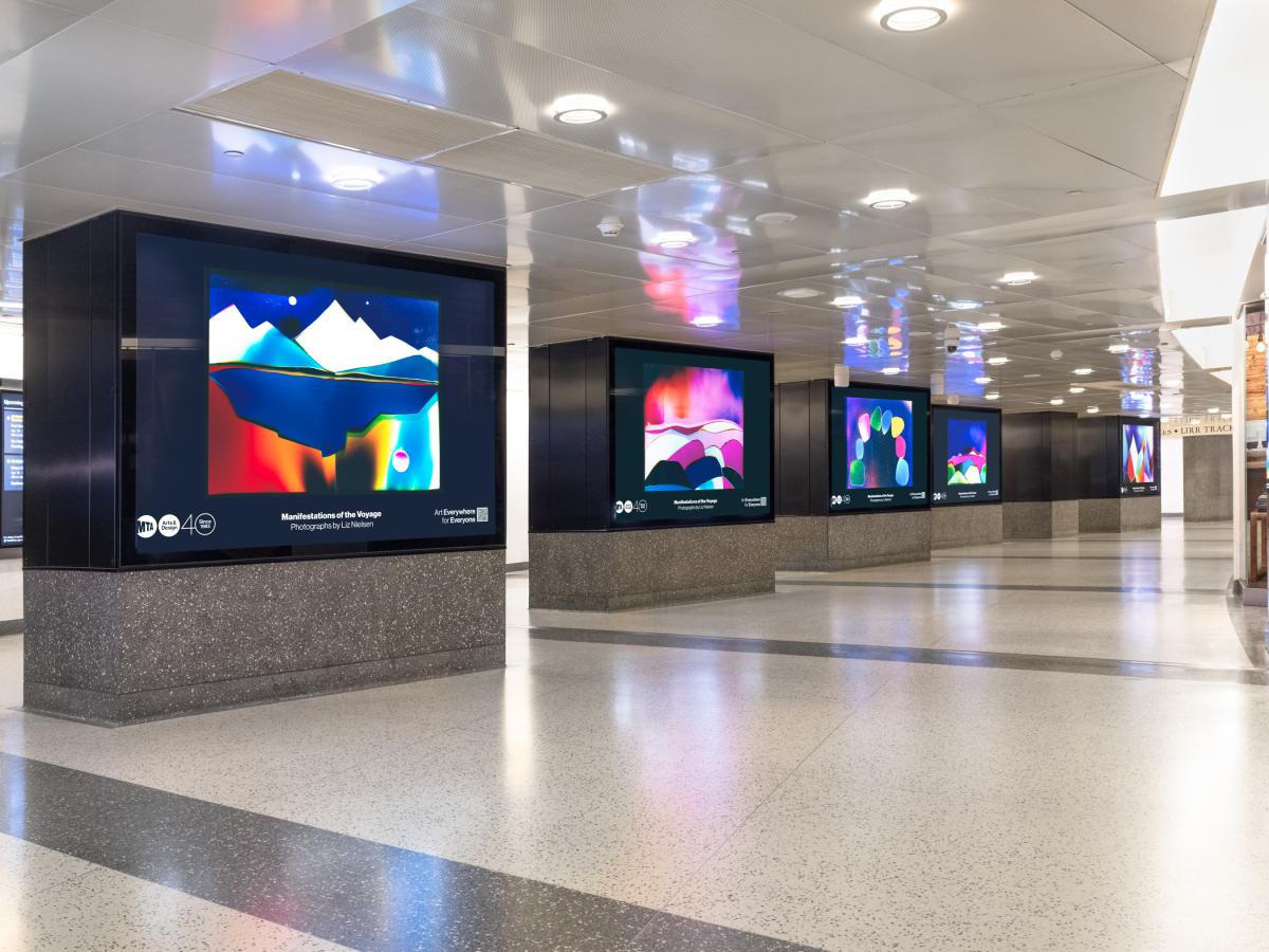 Colorful landscape-like images across multiple screens in hallway
