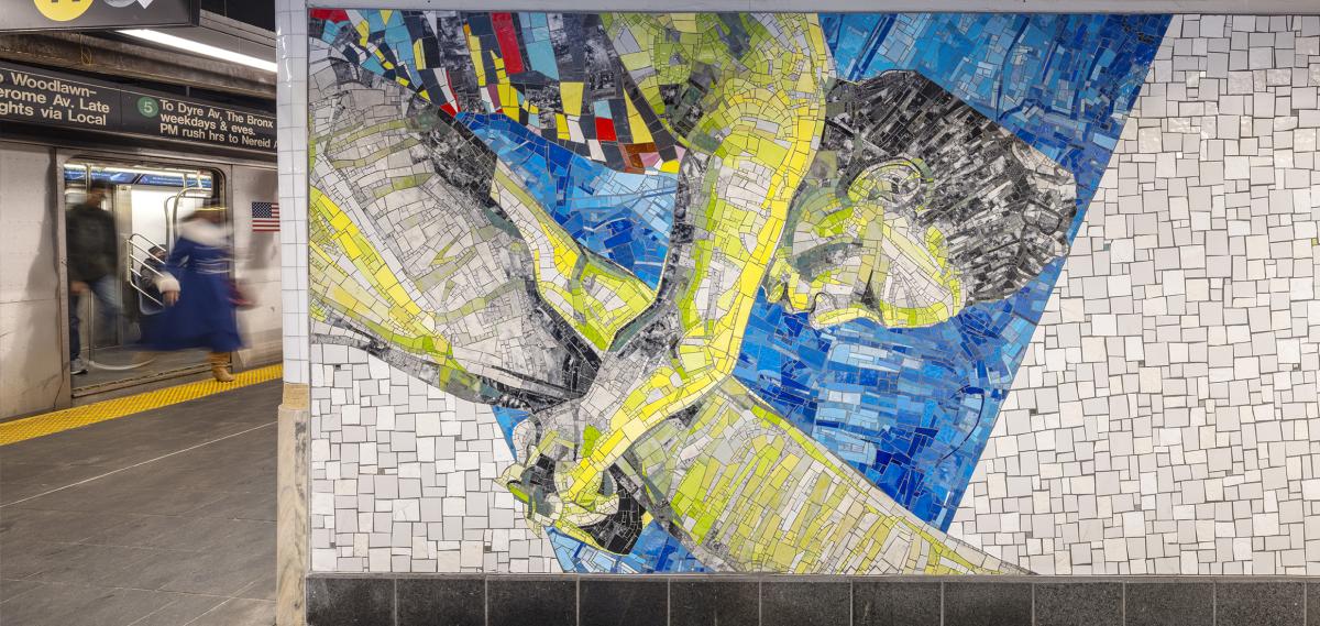 A mosaic mural of a person swimming is displayed on a subway station wall, with a train arriving and passengers on the platform in the background.