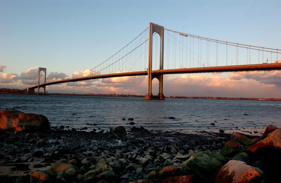 A bridge stretches over a river at sunset