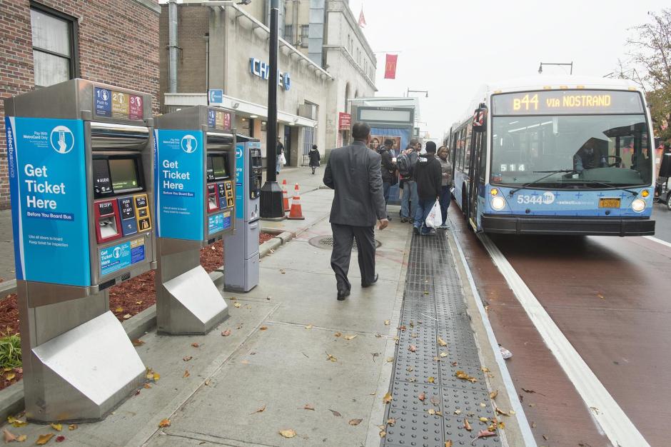 A bus approaching a stop on a busy street