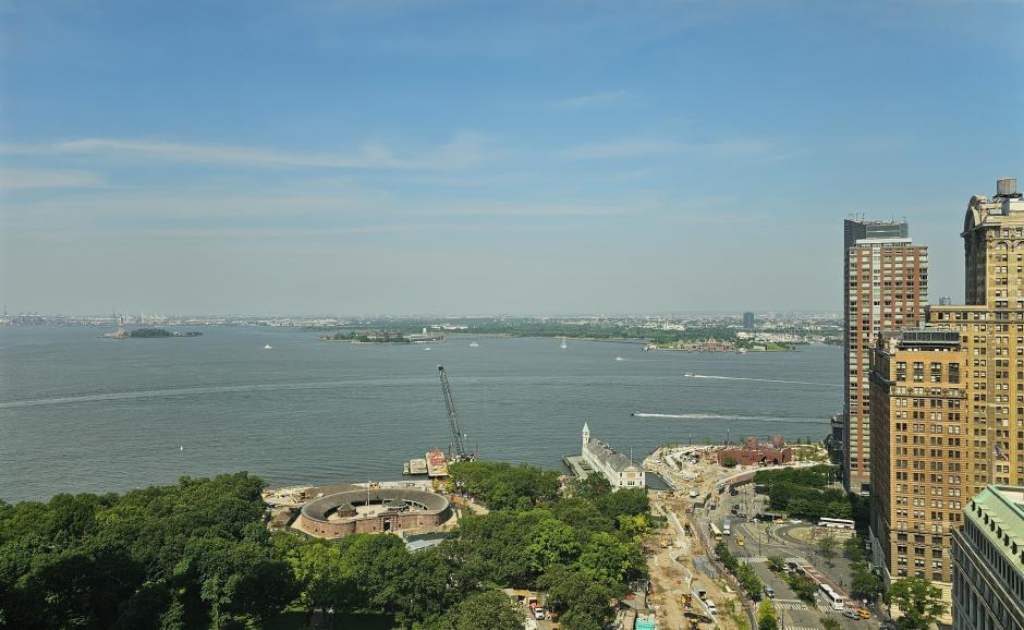A view out a window over Battery Park toward the Statue of Liberty and Ellis Island