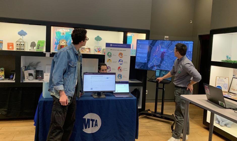 Image of three people standing around a table with various datasets and displays around them