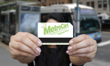 A girl holds a student MetroCard in both hands.