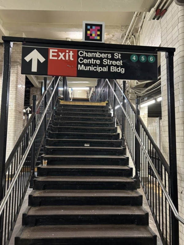NaviLens code next to exit sign at staircase going up.