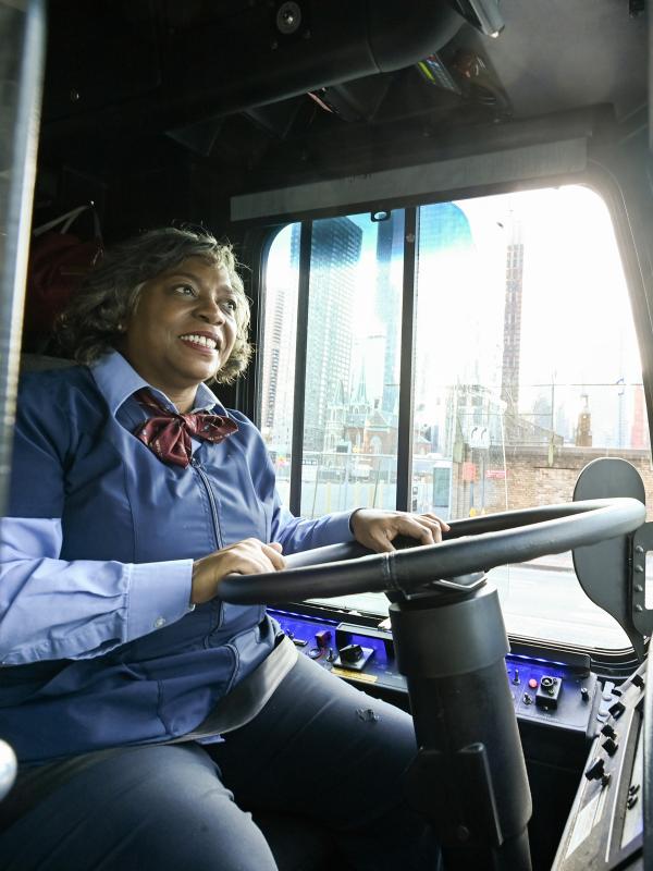 A bus operator behind the wheel of a bus